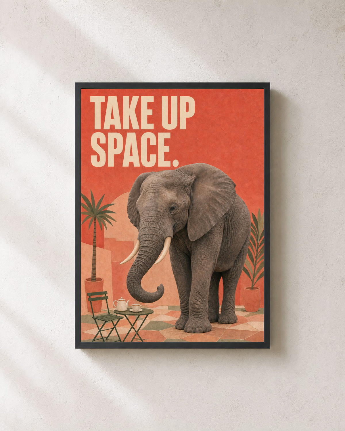 Take Up Space elephant art print with two ivory tusks in a black frame.