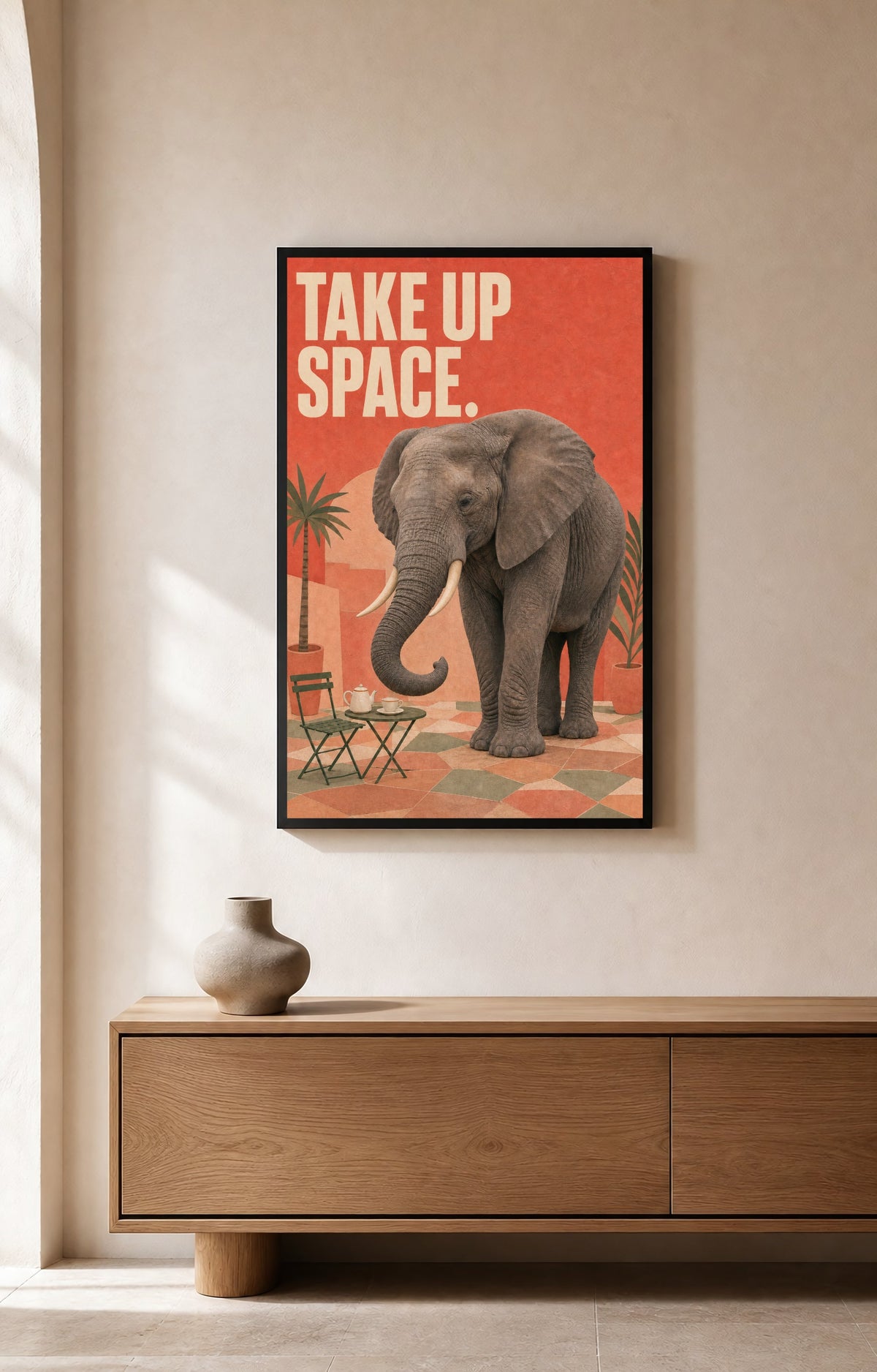 Take Up Space elephant art print with two ivory tusks framed on a warm neutral wall.