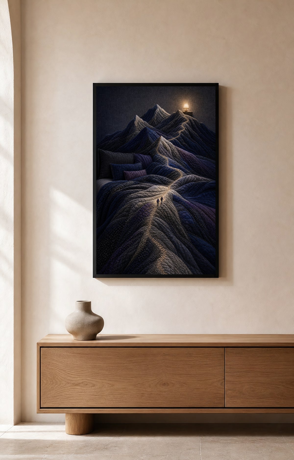 The Bed Became Mountains black-framed art print displayed above a light wood console